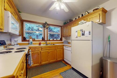 a kitchen with wooden cabinets and a white refrigerator at Humming Bird Crossing in Scaly Mountain