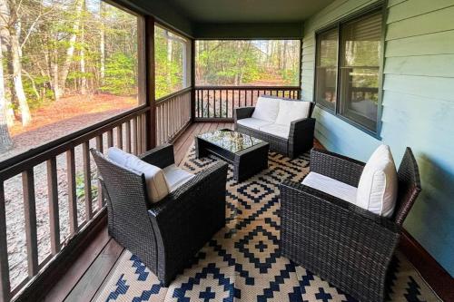 a screened in porch with chairs and a table at Raven's Respite in Saluda