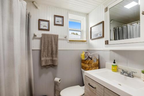 a bathroom with a toilet and a sink and a mirror at LT04FLR Torchbearer - Lower in Little Torch Key