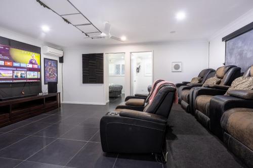 a waiting room with leather chairs and a flat screen tv at SeaBreeze On Todd in Yeppoon