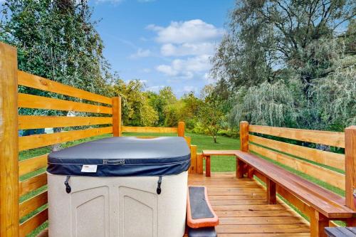 a trash can sitting next to a wooden bench at Meet Me At The Creek in Whittier