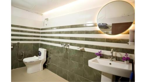 a bathroom with a toilet and a sink and a mirror at Palki Camps and Resorts in Kailāna