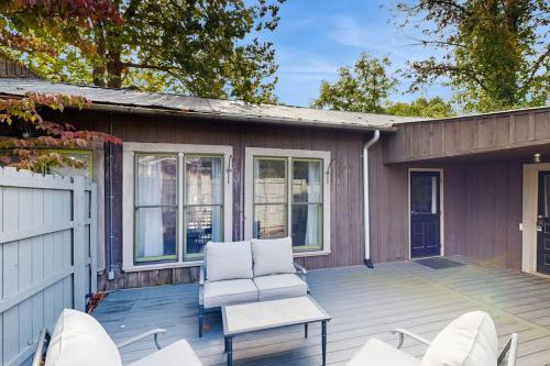 a patio with two chairs and a table on a house at Sassafras Cottage in Waynesville
