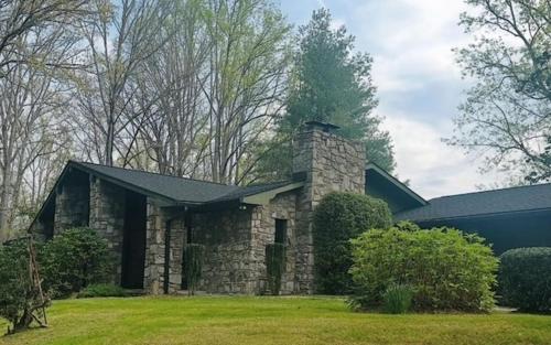 a stone house with a black roof at Riverhill Ridge in Sylva