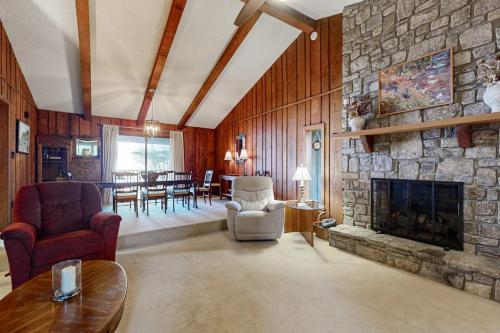 a living room with a stone fireplace and a dining room at Riverhill Ridge in Sylva