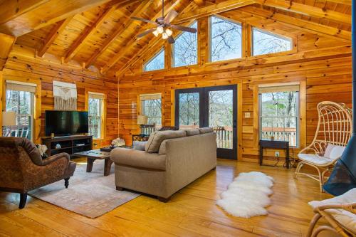 a living room with a couch and a tv at The Lovely Cabin in Black Mountain