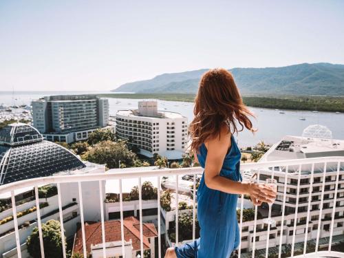 a woman in a blue dress standing on top of a building at Pullman Cairns International in Cairns