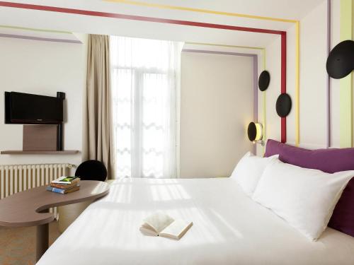a hotel room with a bed with a book on it at ibis Styles Bayonne in Bayonne