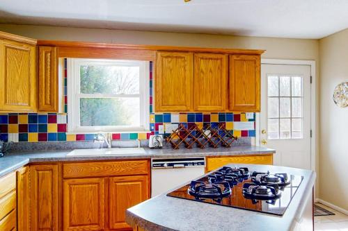 a kitchen with wooden cabinets and a stove top oven at Come Together Place in Candler