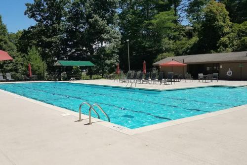 a large blue swimming pool with tables and chairs at The Nunv Cabin in Brevard