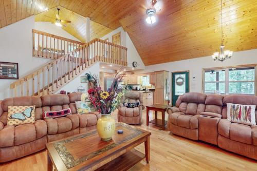 a living room with couches and a table at Talking River Chalet in Murphy