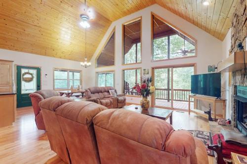 a large living room with leather furniture and a fireplace at Talking River Chalet in Murphy
