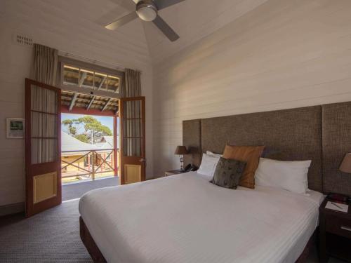 a bedroom with a large white bed and a window at Q Station in Sydney