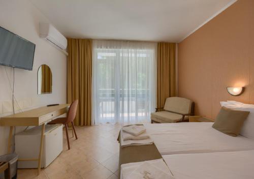 a hotel room with a bed and a desk at Hotel Feniks Lozenets in Lozenets