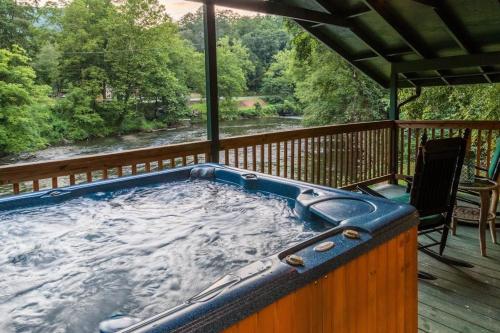 ein Whirlpool auf einer Terrasse mit Blick auf einen Fluss in der Unterkunft River Romance in Sylva