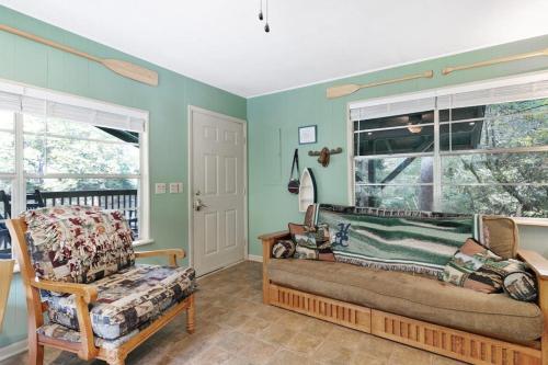 ein Zimmer mit einem Sofa und einem Stuhl und Fenstern in der Unterkunft River Romance in Sylva