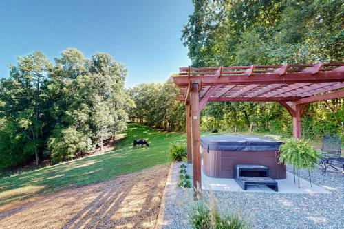 a barbecue under a wooden pergola in a field at Deimos Cabin in Mars Hill