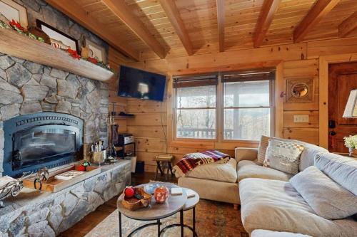 a living room with a stone fireplace in a cabin at Bear Hug in Sylva