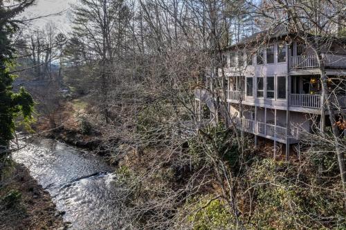 a house on a hill next to a river at Creekside Lodge in Franklin