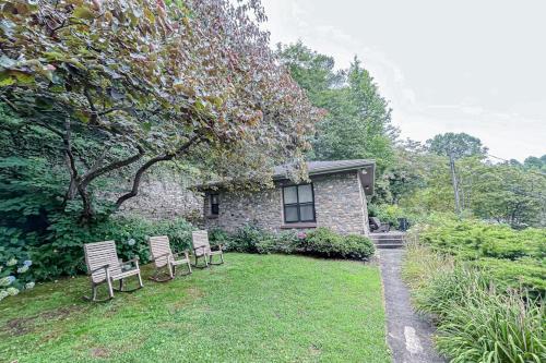 a group of chairs sitting in the yard of a house at Stone Cottage 1973 in Lake Junaluska