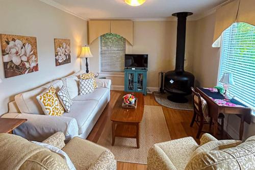 a living room with a couch and a wood stove at Stone Cottage 1973 in Lake Junaluska