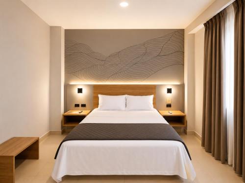 ein Schlafzimmer mit einem großen Bett und einem Gemälde an der Wand in der Unterkunft Senoma Hotel - Adults only in Ica