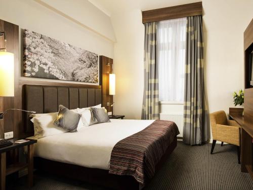 a hotel room with a bed and a desk at Mercure Darlington King's Hotel in Darlington