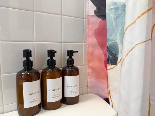 three bottles of essential oils sitting on a shelf in a bathroom at Fifa Walkable King Bed Full Kitchen Central Apartment in Philadelphia