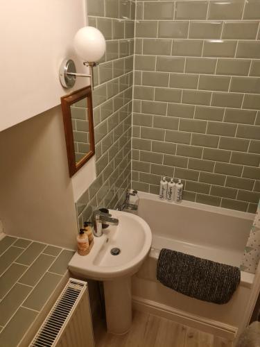 a bathroom with a sink and a bath tub at Bwthyn canol in Sennybridge
