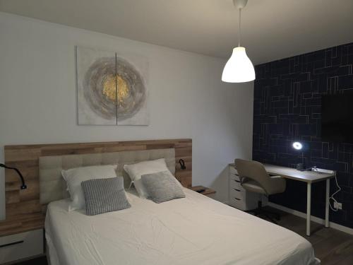 a bedroom with a bed and a desk and a lamp at Duplex Rooftop premium - 4 chambres - Evry in Courcouronnes