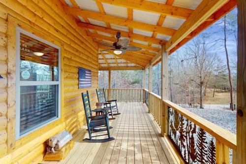 a porch of a wooden cabin with chairs on it at Whispering Pines in Murphy