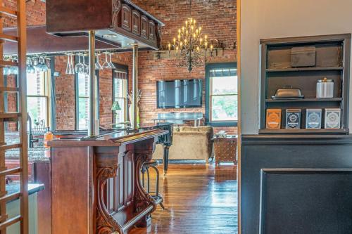 a kitchen with a bar and a living room at Brick Loft Penthouse on Main in Brevard