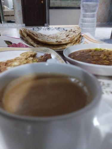a table with a cup of coffee and plates of food at Hotel Multan Avenue Multan in Multan