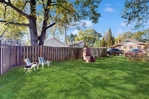 a yard with two chairs and a fence at Main Street Brick Cottage in Brevard