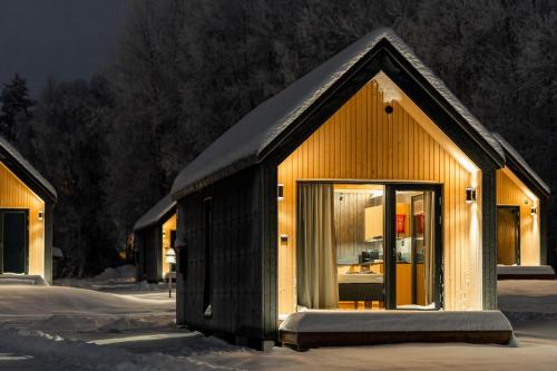 a small house with a pitched roof in the snow at Nilimella Camping & Resort in Sodankylä