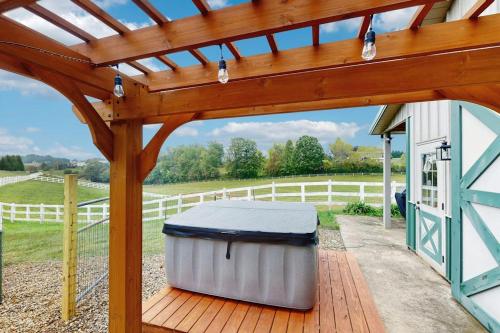 a metal trash can on a deck under a wooden pergola at Gibbs Getaway in Leicester