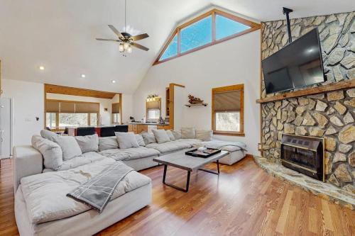 a living room with a couch and a stone fireplace at Pebble on The Creek in Whittier