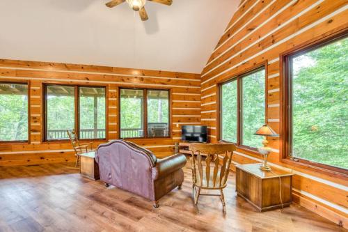 a living room with wooden walls and a ceiling fan at Close to Heaven in Sylva