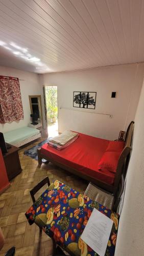 a bedroom with a red bed in a room at Kitnet Da Cláudia e Geovani in Miguel Pereira