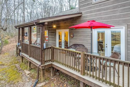 a house with a deck with a red umbrella at Tree Top Cabin in Sylva