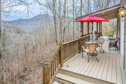 a wooden deck with a table and an umbrella at Tree Top Cabin in Sylva
