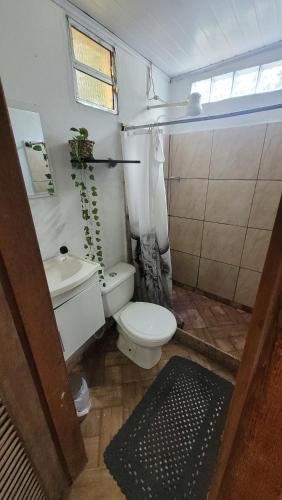 a small bathroom with a toilet and a sink at Kitnet Da Cláudia e Geovani in Miguel Pereira