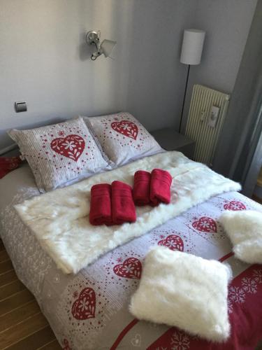uma cama com cobertores e almofadas vermelhos e brancos em Gite Chamonix Mont Blanc LYRET em Chamonix-Mont-Blanc