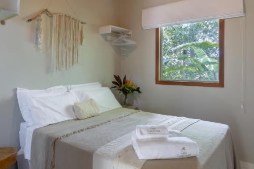 a bedroom with a bed with two towels on it at Casa Cuca Fresca , 2 Suítes e a 400m das Piscinas Naturais reservadas in Marau