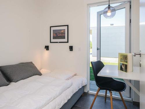 a bedroom with a bed and a desk and a table at 4 star holiday home in Ringkøbing in Ringkøbing