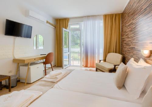 a hotel room with a large bed and a desk at Hotel Feniks Lozenets in Lozenets