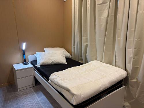 a small bed in a room with a curtain at Cabin 6- Snowy Accommodation in Adaminaby