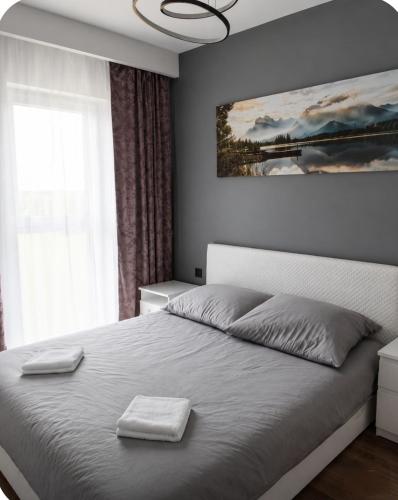 a bedroom with a bed with two towels on it at Apartamenty Zator Jaśminowa in Zator
