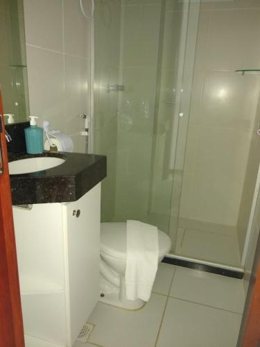 a white bathroom with a toilet and a shower at Apto 2/4 resort TreeBies- Subaúma in Subaúma