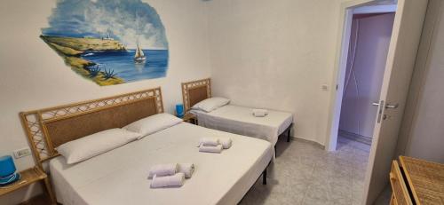a room with two beds and a painting on the wall at Residence Villa delle Rose in Lampedusa